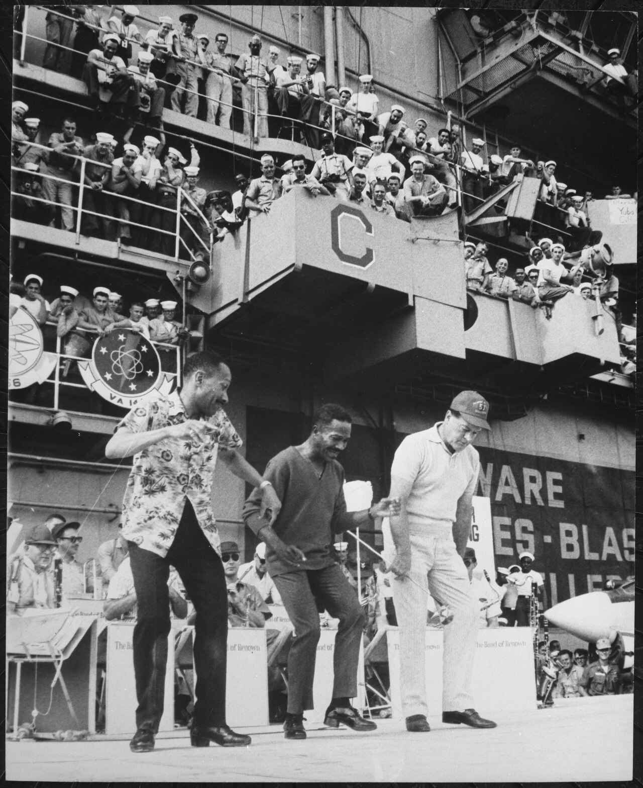 Hollywood comedian Bob Hope joins dancers Harold and Fayard Nicholas in a dance step aboard the U.S. aircraft carrier Ti - NARA