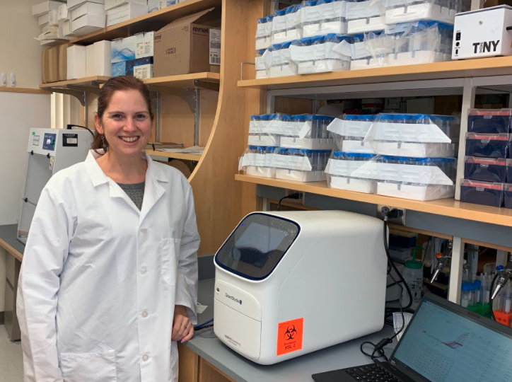 Anne Wyllie, scientist from New Zealand, standing at work station