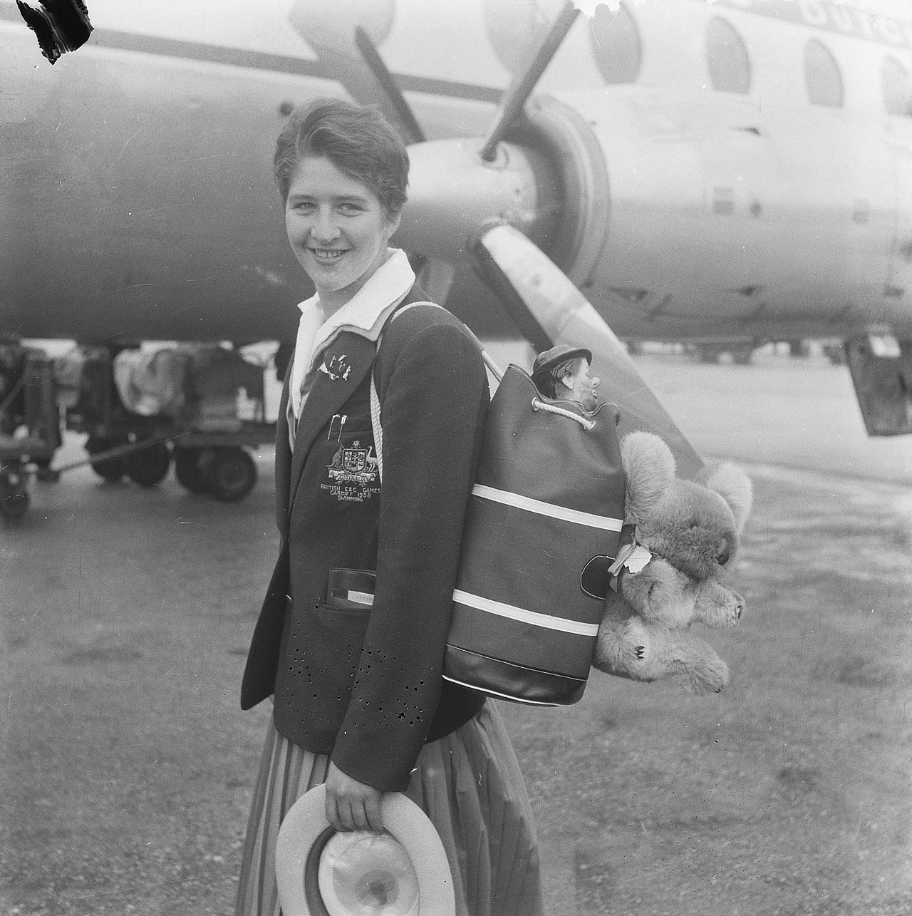 Aankomst Australische zwemploeg op Schiphol, Dawn Fraser met rugzak en talisman, Bestanddeelnr 909-7649